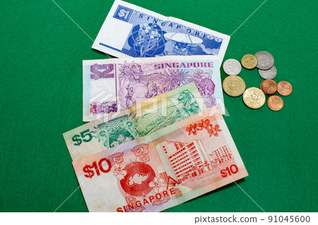 Singapore dollars, banknotes and coins on green background 91045600