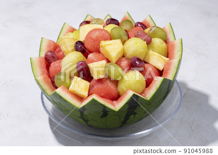 Assorted heaps of fruit with hollowed out watermelon skin 91045988