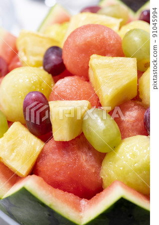 Assorted heaps of fruit with hollowed out watermelon skin 91045994