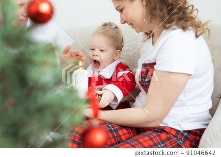 Baby child with hearing aid and cochlear implant having fun with parents in christmas room. Deaf , diversity and health concept 91046642