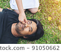 nurse giving cardiopulmonary resuscitation to man on grass park 91050662