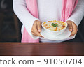 hand woman suggesting exquisite restaurant appetizer Spinach with cheese in white bowl 91050704