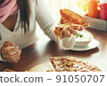 female models eating pizza on wood table blurred 91050707