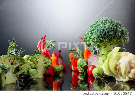 Various raw vegetables on a black reflective background. Various raw vegetables on a black reflective background. 91050847