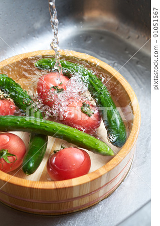Wash the cucumbers and tomatoes in a tub Wash the cucumbers and tomatoes in a tub 91051567