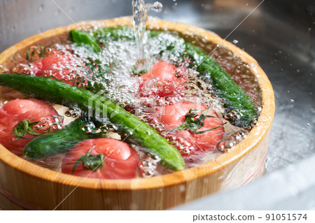 Wash the cucumbers and tomatoes in a tub 91051574