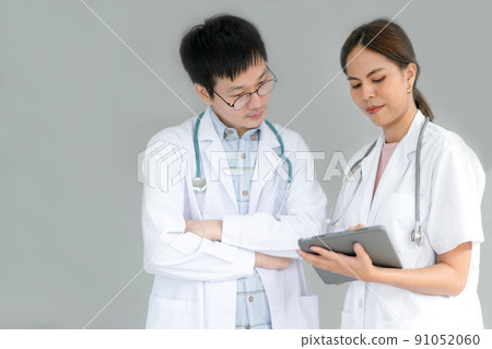Team of doctors consults about patients by tablet for Telemedicine treatment. 91052060