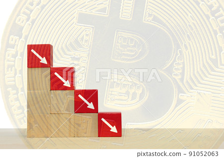 Arrow pointing down on red wooden block.  Symbol of the fall of Bitcoin and cryptocurrency on abstract background 91052063