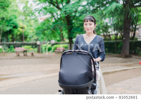 Mom pushing the stroller with a smile Mom pushing the stroller with a smile 91052601