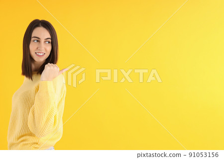 Attractive girl in sweater on yellow background 91053156