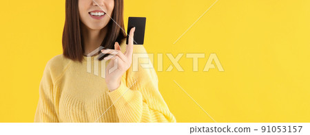 Young attractive girl with card on yellow background 91053157