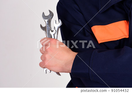 Man holds wrench tools isolated on white background. 91054432