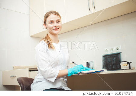 beautiful woman dentist in office, in clinic, indoor. Portrait, smiling and happy. Friendly doctor. young student of medical university 91054734