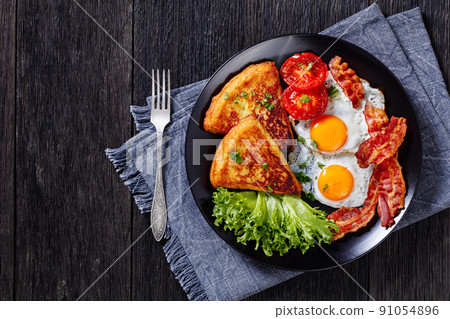 irish breakfast of fried eggs, bacon, potato farls 91054896