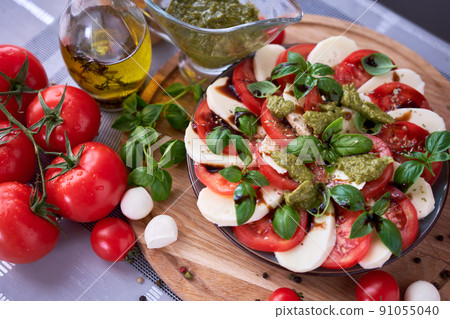 Caprese salad - sliced mozzarella cheese and tomatoes Caprese salad - sliced mozzarella cheese and tomatoes 91055040