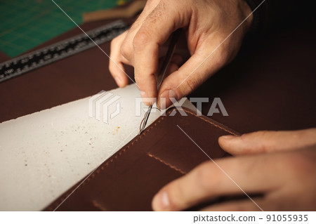tanner makes leather wallet, professional craftsman, closeup, business Handiwork 91055935
