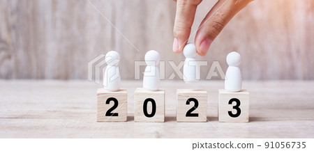 hand holding businessman over block building with 2023 text. leadership, business, team, teamwork and New Year Resolution concept hand holding businessman over block building with 2023 text. leadership, business, team, teamwork and New Year Resolution concept 91056735
