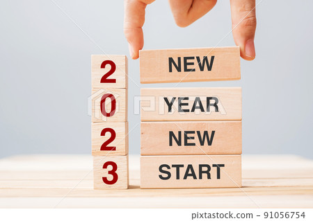 hand holding wooden block with text 2023 NEW YEAR NEW START on table background. Resolution, strategy, solution, business and holiday concepts hand holding wooden block with text 2023 NEW YEAR NEW START on table background. Resolution, strategy, solution, business and holiday concepts 91056754