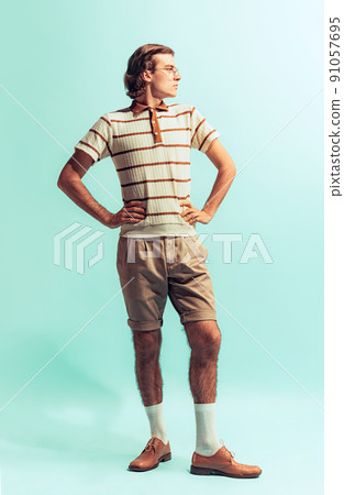 Full-length portrait of young man in retro style outfit posing isolated over light blue studio background 91057695