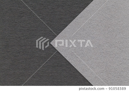 Texture of gray and black paper background, half two colors with arrow, macro. Structure of dense craft grey cardboard. Texture of gray and black paper background, half two colors with arrow, macro. Structure of dense craft grey cardboard. 91058389