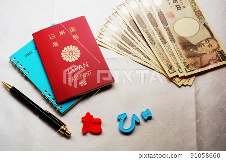 Passport, pen, 10,000 yen note placed on the notebook 91058660