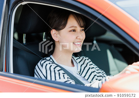 Young woman driving a car with a smile 91059172