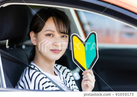 Young female driver with a beginner mark 91059173