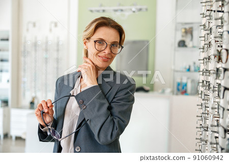 Businesswoman chooses a spectacle frame in an optician's shop 91060942
