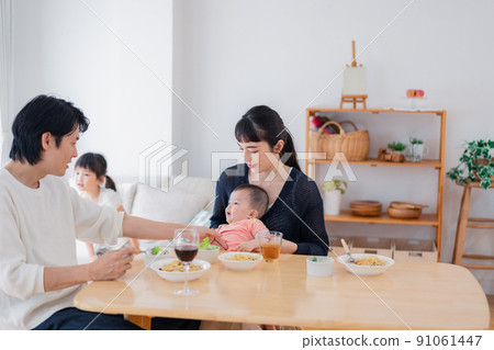 Family surrounding children and dining table 91061447