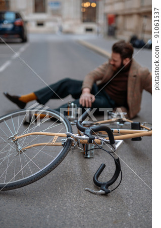 Bicycle accident in city. Man cyclist fell off road bike while cycling. Bike injurie, injured knee Bicycle accident in city. Man cyclist fell off road bike while cycling. Bike injurie, injured knee 91061537