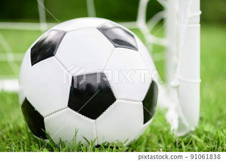 Generic black and white football (soccer) ball next to mini goal Generic black and white football (soccer) ball next to mini goal 91061838