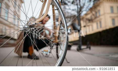 Man checking wheels on bike. Repairing bicycle at street. Background Man checking wheels on bike. Repairing bicycle at street. Background 91061851