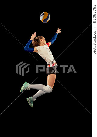 Dynamic portrait of professional volleyball player in sports uniform playing volleyball isolated on dark background. Sport, healthy lifestyle, team, action, motion concept 91062762