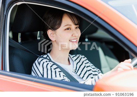 Young woman driving a car with a smile 91063196