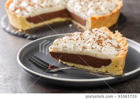 Coconut Haupia and Chocolate Pie topped with whipped cream closeup in the plate. Horizontal Coconut Haupia and Chocolate Pie topped with whipped cream closeup in the plate. Horizontal 91063729