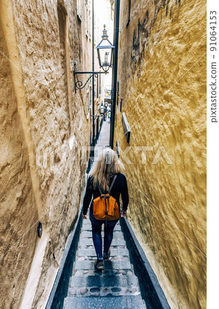 Woman in the narrowest street of Stockholm Woman in the narrowest street of Stockholm 91064153