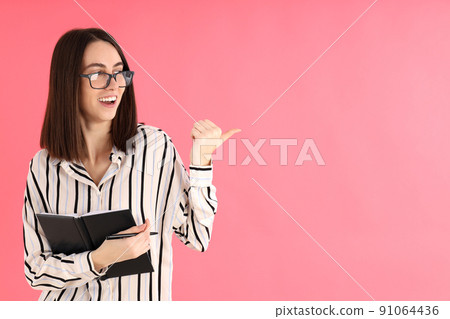 Young attractive woman in glasses on pink background Young attractive woman in glasses on pink background 91064436