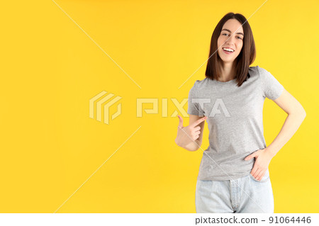Young attractive woman in t-shirt on yellow background 91064446