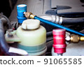 Servicing car air conditioner in vehicle service or repair workshop close-up 91065585