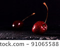 Sweet fresh red cherries on black stone background. Black background with space for text. Drops of water on the berries. 91065588