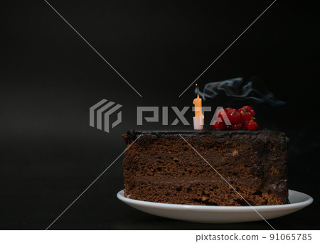 Piece of chocolate birthday cake with one extinguished candle on white plate on deep black background. Birthday party, celebration, anniversary. Close-up, copy space for your text. Piece of chocolate birthday cake with one extinguished candle on white plate on deep black background. Birthday party, celebration, anniversary. Close-up, copy space for your text. 91065785