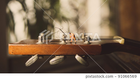 The technician worker figure fixing old guitar strings. 91066569