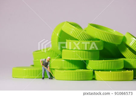 Worker figure standing on plastic cap. Recycle material concept. Worker figure standing on plastic cap. Recycle material concept. 91066573