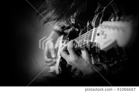 A young man plays the electric guitar 91066687