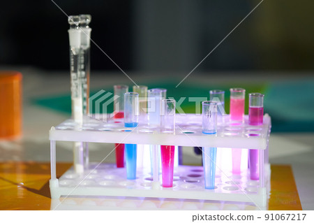 Solution in a scientific glass flask against the background of a school chemistry laboratory. Chemical laboratory tableware with colored liquids. High quality photo Solution in a scientific glass flask against the background of a school chemistry laboratory. Chemical laboratory tableware with colored liquids. High quality photo 91067217