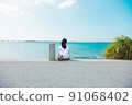 A girl traveling alone to Okinawa looks at the sea 91068402