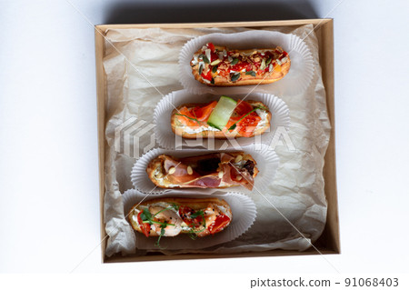 Eclairs with salmon, fresh vegetables and herbs, gourmet snacks. 91068403