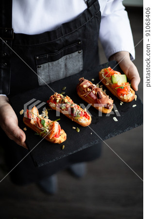 Eclairs with salmon, fresh vegetables and herbs, gourmet snacks. 91068406