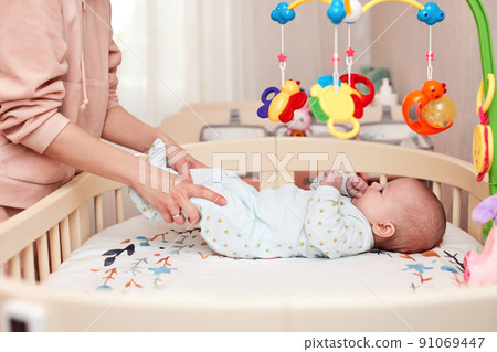 Baby massage. Mother doing gymnastics with newborn child Baby massage. Mother doing gymnastics with newborn child 91069447