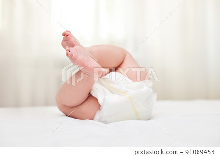 Cute little baby in diaper on bed. 91069453